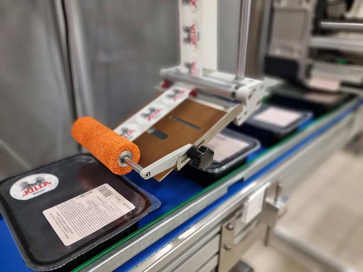 Аппликатор Savema наносит верхнюю этикетку на лоток с продукцией