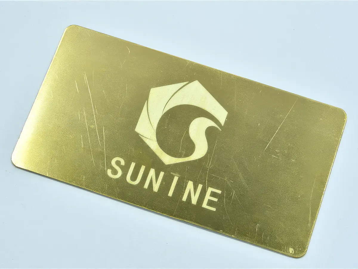 Гравировка логотипа Sunine на латунной пластине лазером Sunine Fiber — золая контрастность и точность