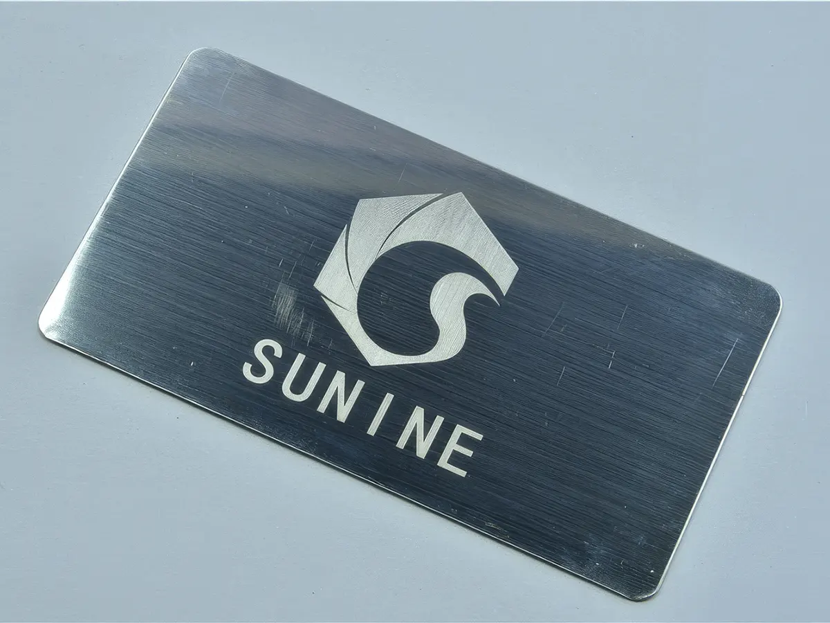 Гравировка логотипа Sunine на латунной пластине лазером Sunine Fiber — серая контрастность и точность