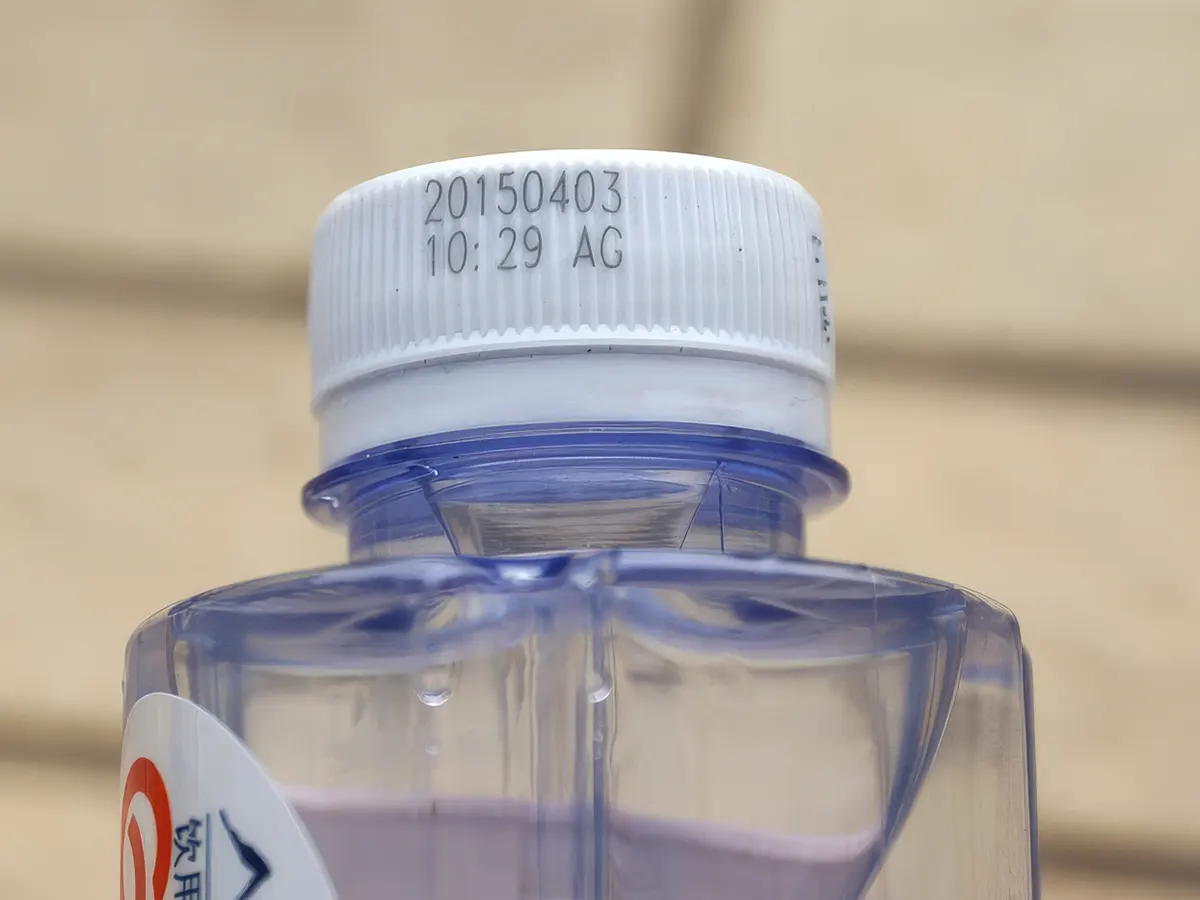 Лазерная маркировка даты и времени на пластиковой крышке бутылки с водой ультрафиолетовым лазером Sunine UV