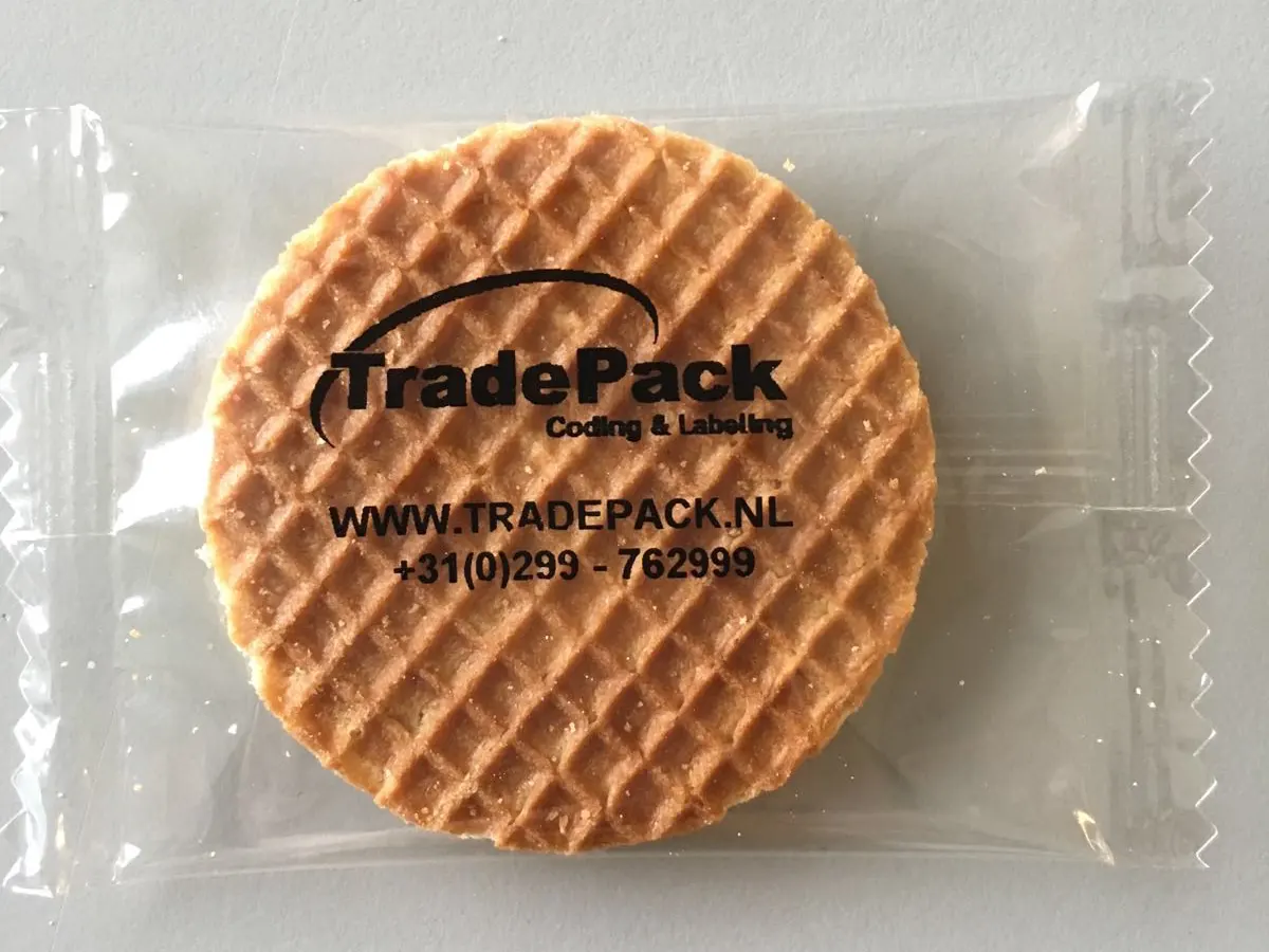 Круглая вафля в прозрачной упаковке с чёрным логотипом TradePack и контактами